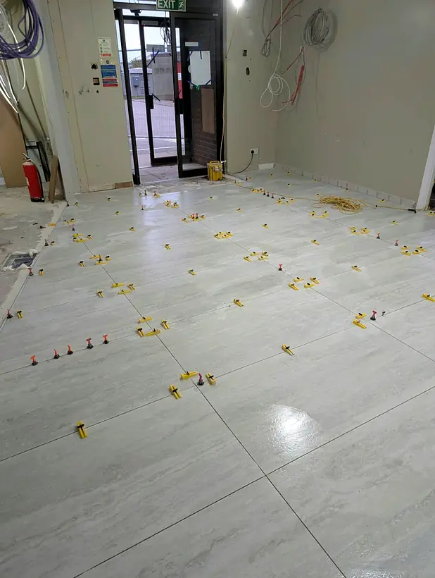 60 × 120 cm floor tiles being laid with a levelling system in an office in Dyce