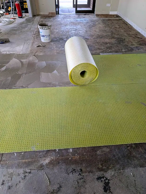 Stripped floor with decoupling membrane being laid