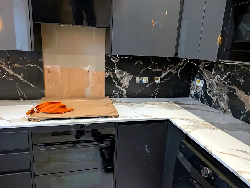 Marble effect splashback with the hob wall still to tile