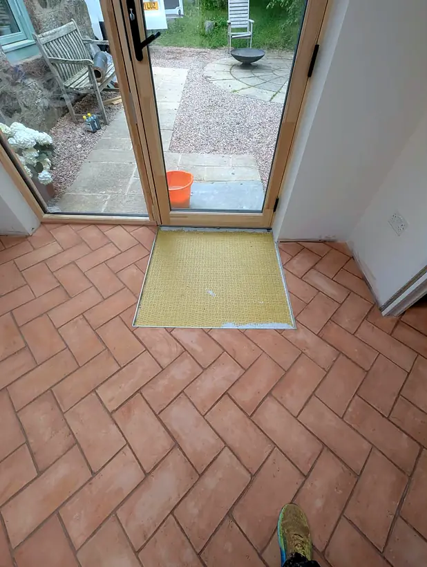 Terracotta herringbone floor with the last section of membrane exposed